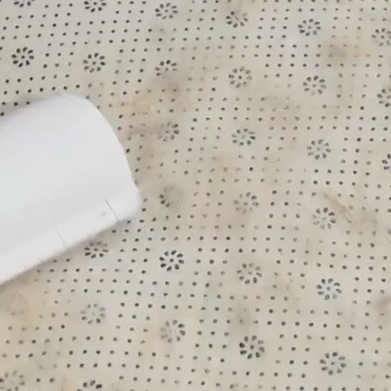 Demo of the reusable roller lifting dog hair from fabric and emptying the hair chamber