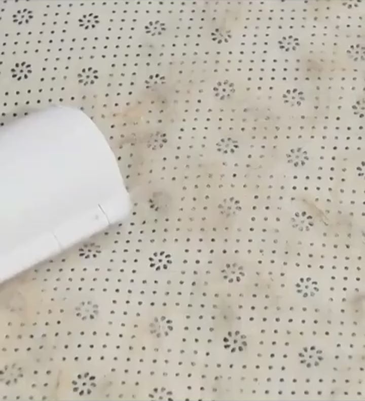 Demo of the reusable roller lifting dog hair from fabric and emptying the hair chamber